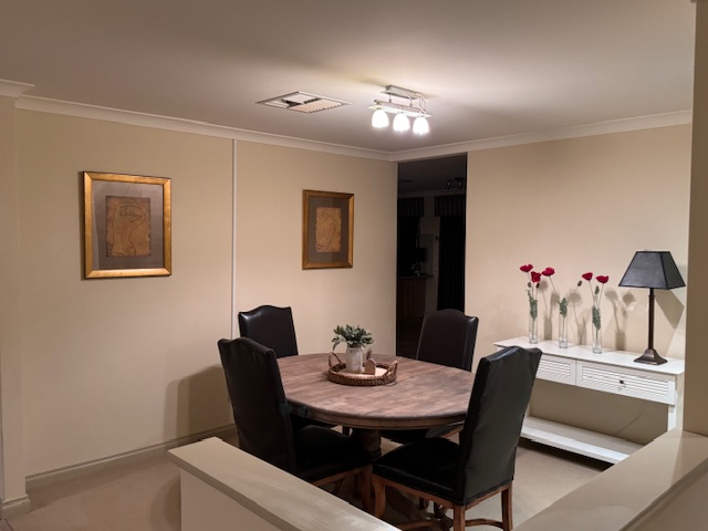 Dining room with round table and framed art.