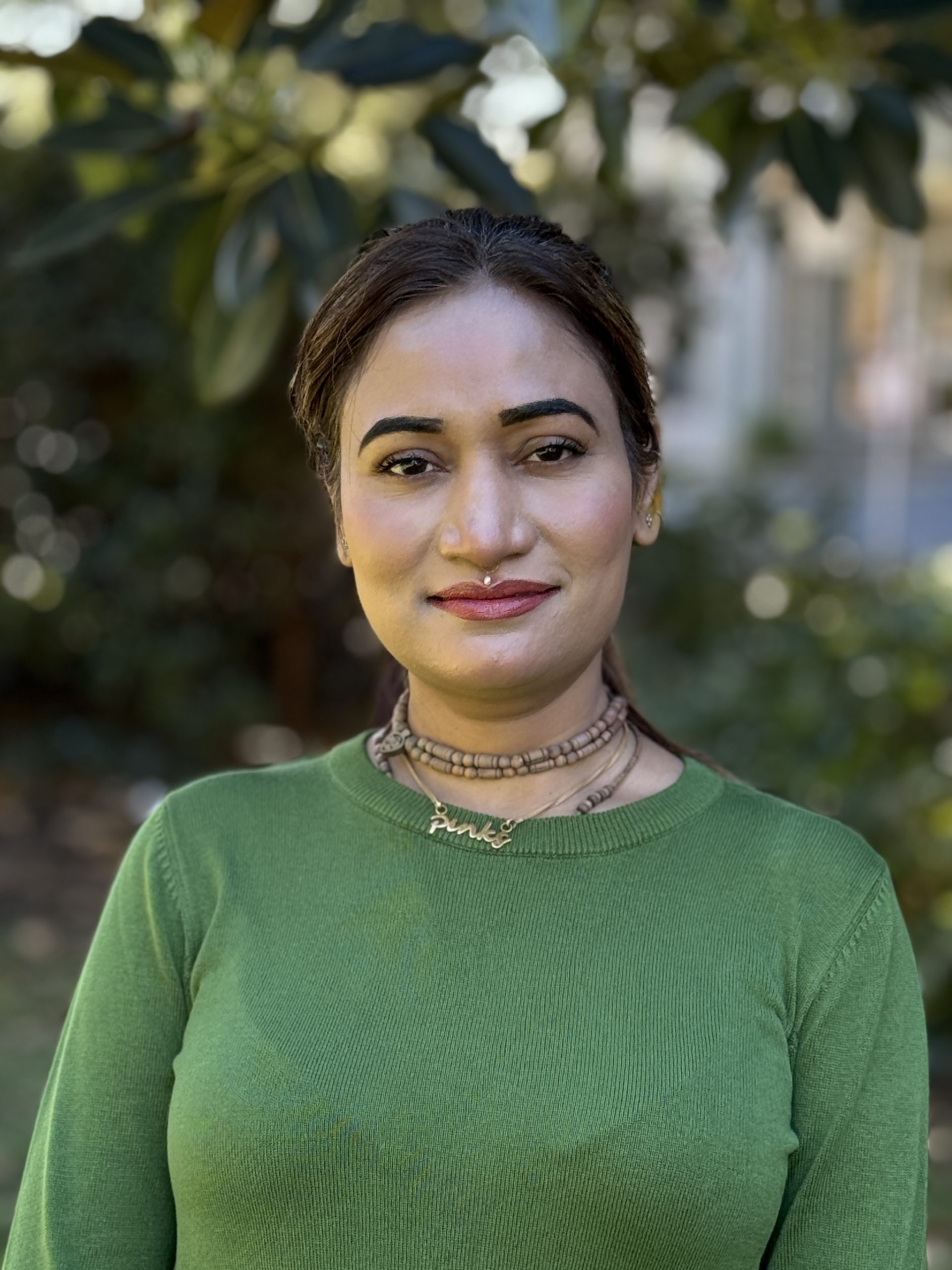 Person in green top, outdoors portrait